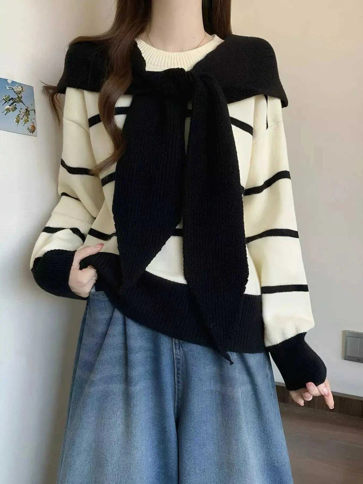 Striped Round Neck cream sweater with black horizontal stripes, long sleeves, and layered black knit tie detail