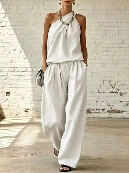 Full Size Sleeveless Top and wide-leg pants set in white satin-like fabric, with draped neckline and pockets