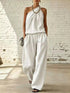 Full Size Sleeveless Top and wide-leg pants set in white satin-like fabric, with draped neckline and pockets