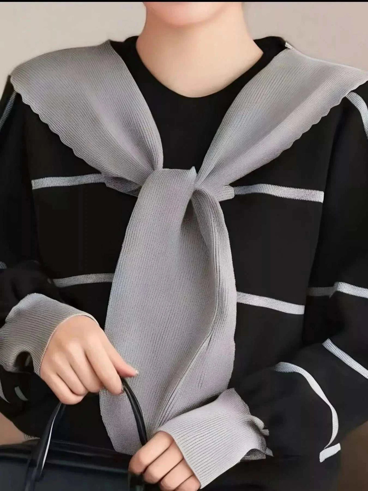 Striped Round Neck black sweater with white horizontal stripes and a tied gray knit scarf detail