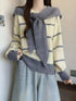 Striped Round Neck sweater in cream with gray stripes, knit material, and a tied gray scarf detail.